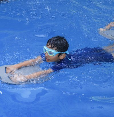 Untitled deBuilding Confidence, One Stroke at a Timesign Children learning to swim at Titan Pro Sports Academy indoor pool in Sharjah, developing water confidence and swimming skills.